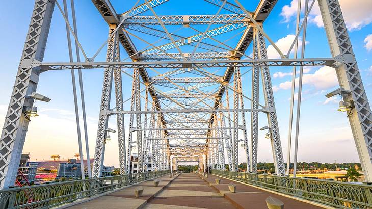 A pedestrian bridge with a steel frame and city views on either side A pedestrian bridge with a steel frame and city views on either side