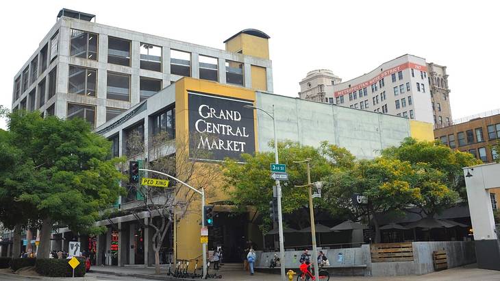 A building with a yellow wall and a sign that says "Grand Central Market" A building with a yellow wall and a sign that says "Grand Central Market"