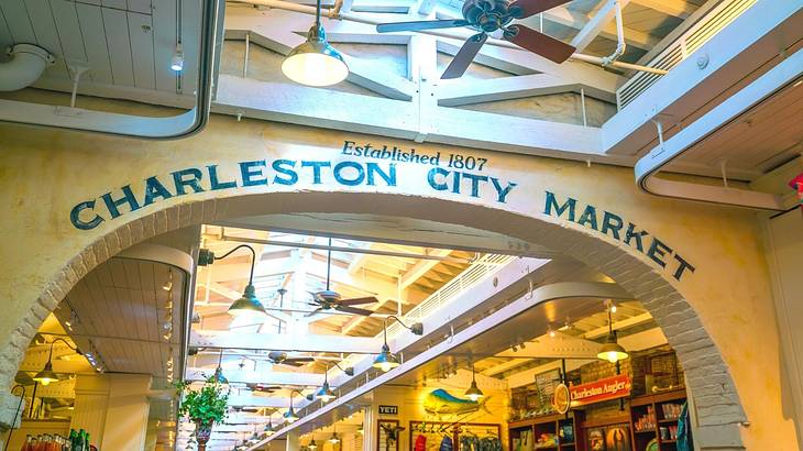 A yellow wall with an archway and the words "Charleston City Market" in green