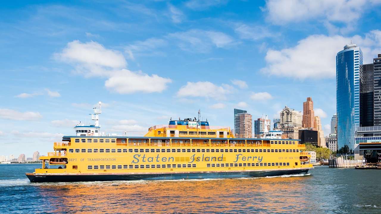 A yellow Staten Island Ferry entering Manhattan on a clear day