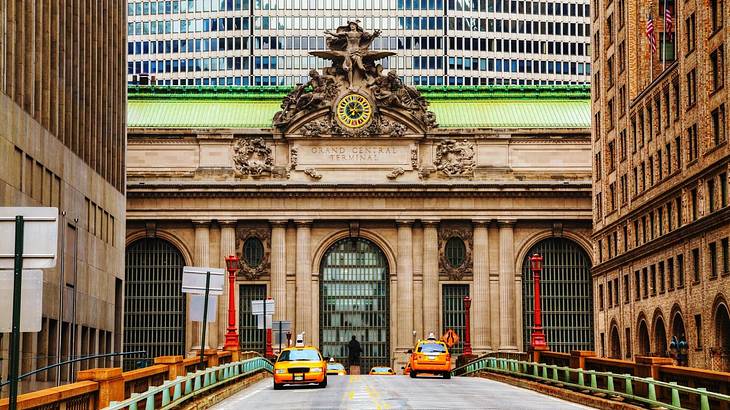 A view of Grand Central Station with a road with yellow taxi cabs in front of it