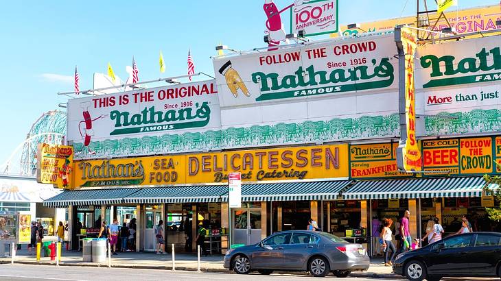 A restaurant building with billboards of "This is the original Nathan's Famous" A restaurant building with billboards of "This is the original Nathan's Famous"