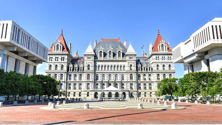 A capitol building with Romanesque Revival architecture under a clear blue sky