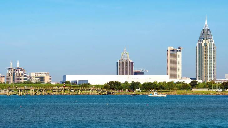 A bay of water with some buildings and grass on the shore