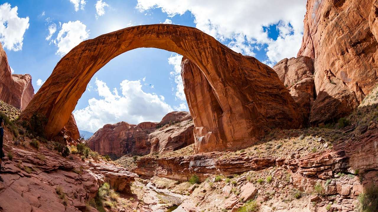A red sandstone arch surrounded by rocky cliffs