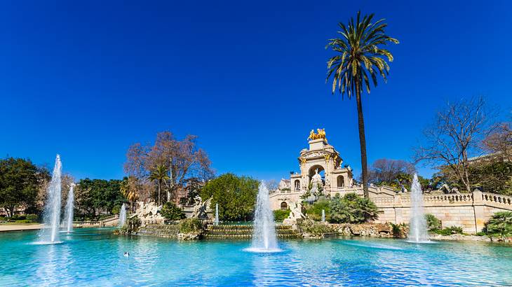 A fountain in front of a monument with various sculptures and stairs on either side