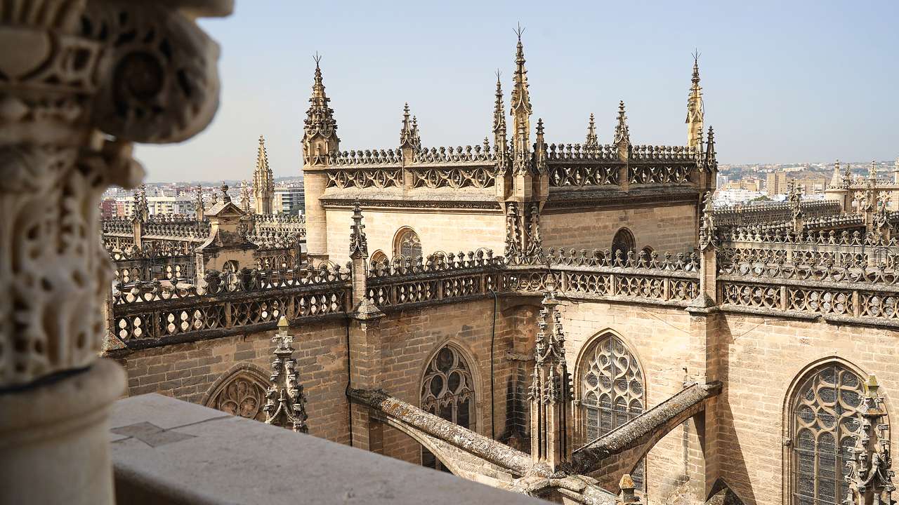 Looking through a tower window onto the pointed tops of a church's square roofs