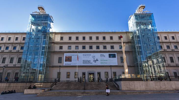 The facade of a building with two elevators enclosed in glass columns