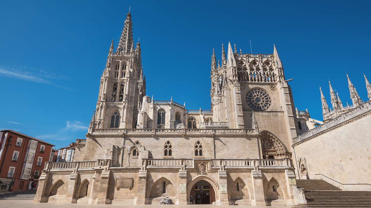 The facade of a Gothic cathedral made of limestone against a clear blue sky