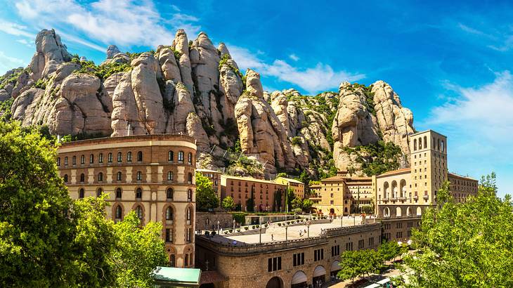 A monastery surrounded by greenery, sitting in a mountain, on a sunny day