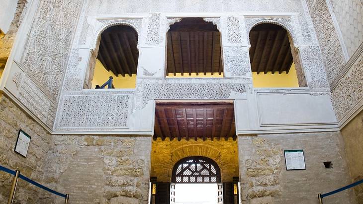 The interior of a synagogue with arched windows and white and yellow accents