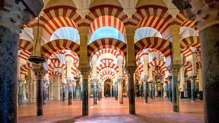 A view of rows of stone arches painted with red and white stripes