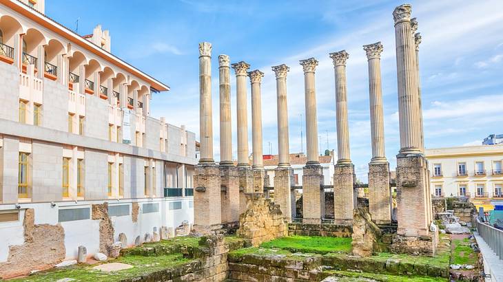 A set of ruins with stone columns next to a building