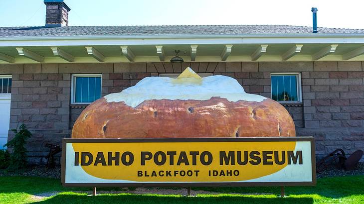 Looking at a sign of "Idaho Potato Museum" with a potato against a brick house