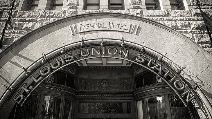 A gray stone building with an arched entrance and a sign of "St. Louis Union Station"