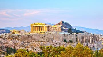 An ancient Greek structure with many columns under a pink-blue sky