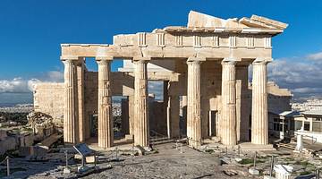 A worn-out marble structure with columns under a clear blue sky