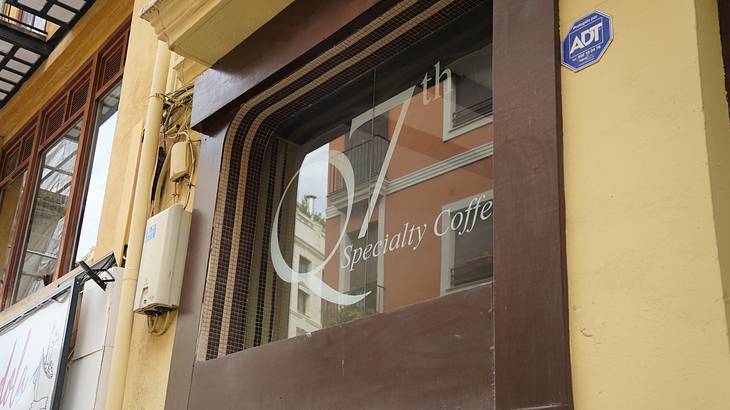 Entranceway signage for a coffee shop, white writing on glass
