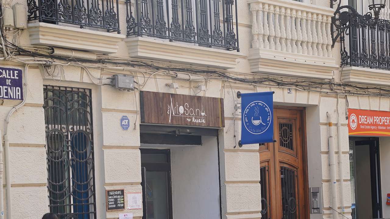The entrance way to a coffee shop with brown signage at the top