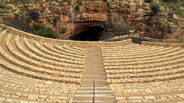 Round, rocky, wide steps leading downwards to a cave Round, rocky, wide steps leading downwards to a cave