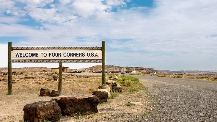 A sign that says "Welcome to Four Corners U.S.A" next to a road A sign that says "Welcome to Four Corners U.S.A" next to a road