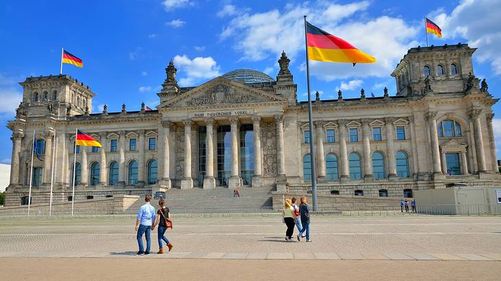 A stone building with columns and German flags in front of it