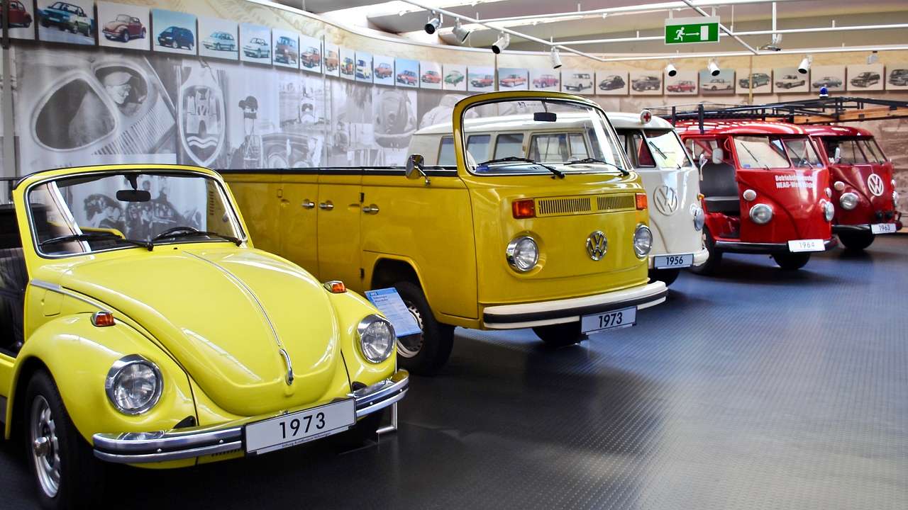 A row of colorful Volkswagen vehicles in a museum