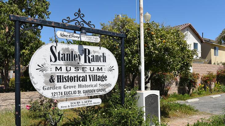 A sign that says "Stanley Ranch Museum and Historical Village" next to a house