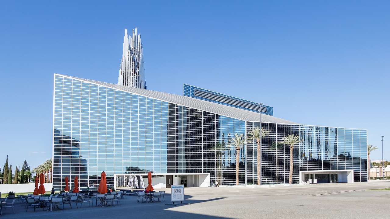 A mirrored building next to a mirrored tower under a clear blue sky