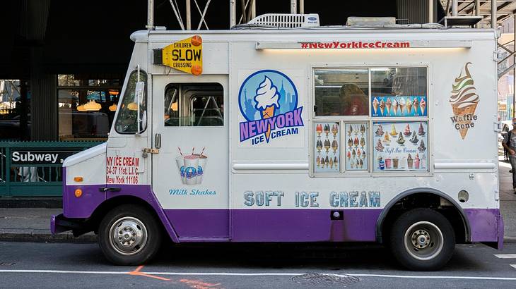 A white and purple ice cream truck with signage next to an NYC subway sign