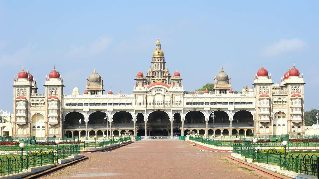 The exterior of an Indian palace with a path and grass in front of it
