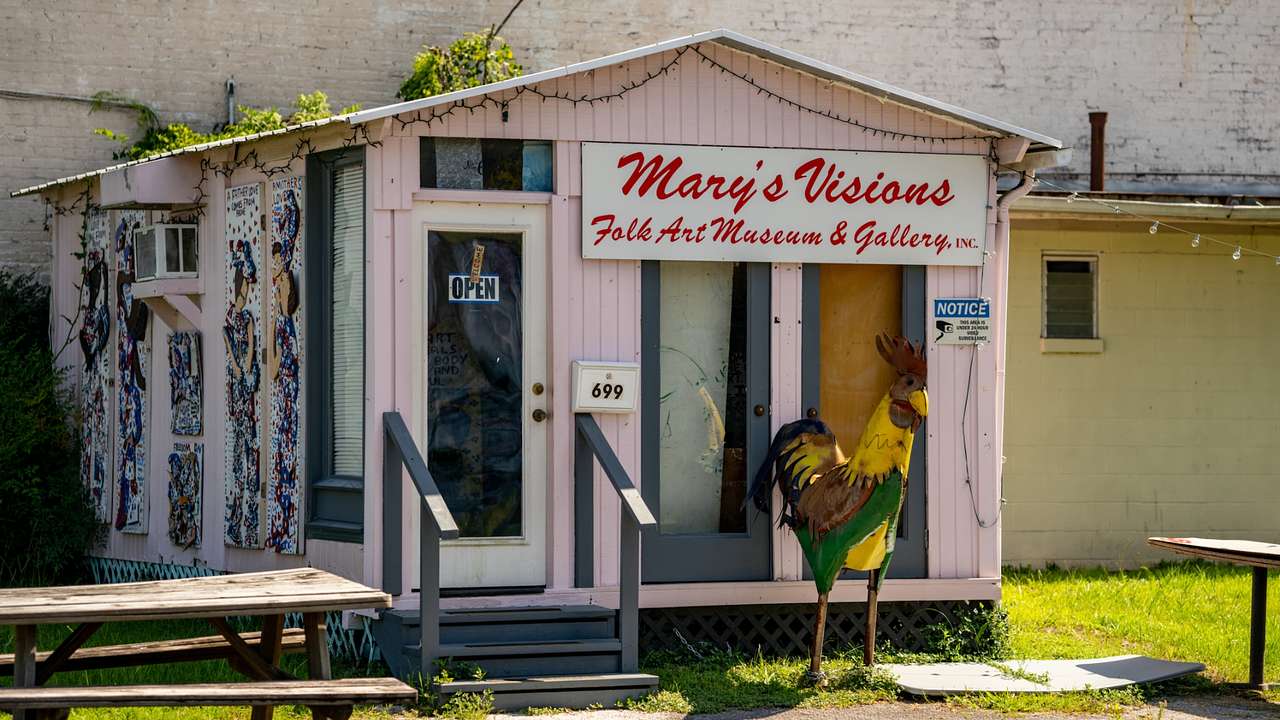 A pink shed with a "Mary's Visions Folk Art Museum and Gallery" sign