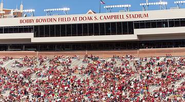A stadium with a "Doak S. Campbell Stadium" sign and people wearing red in the stands