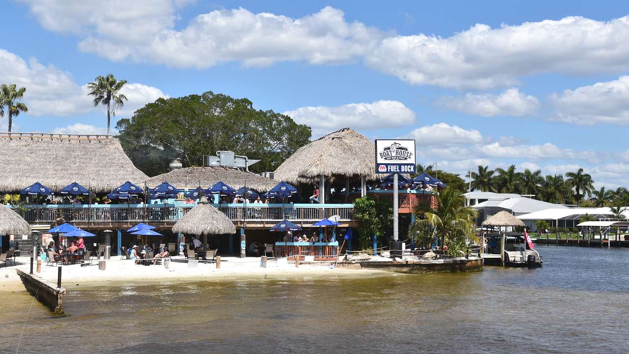 A waterfront restaurant with sun umbrellas and a sign that says "Boathouse"