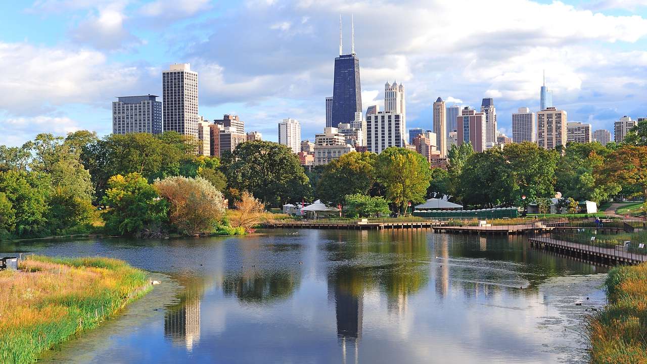 The Chicago city skyline next to a park with a lake and green trees