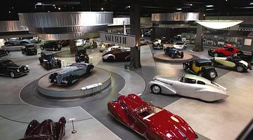 A view of a museum with vintage cars on display