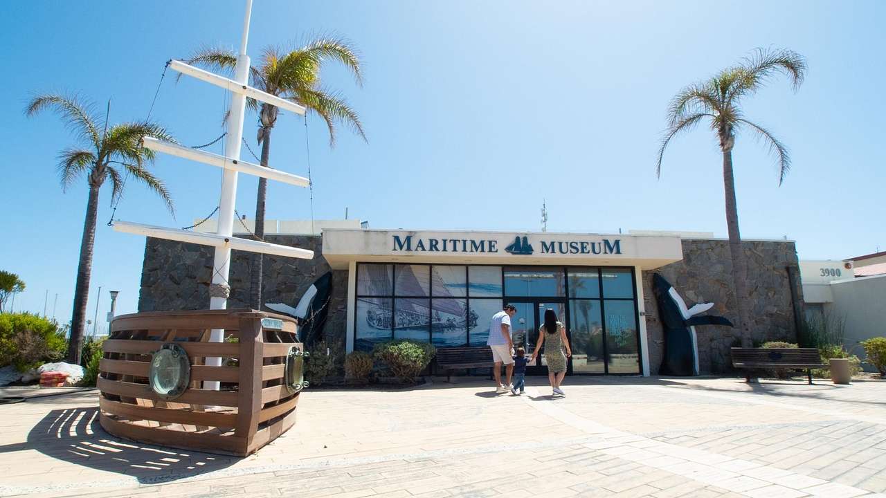 A museum with a "Maritime Museum" sign next to palm trees and a boat structure