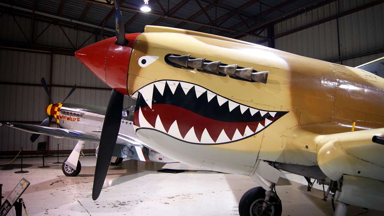 A military jet with a face painted on it in an air hangar