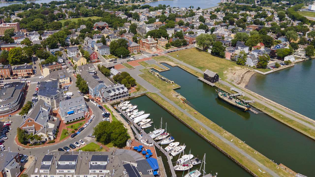 An aerial view of brick buildings around a harbor with white boats
