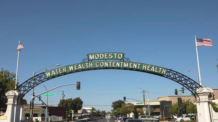 A green arch that says "Modesto, Water, Wealth, Contentment, Health"