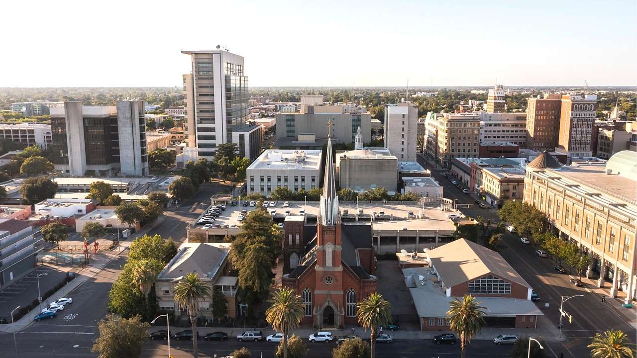 A view over the city of Stockton with a red brick church, other buildings, and trees