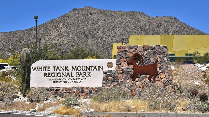 A hill behind a sign that says "White Tank Mountain Regional Park"