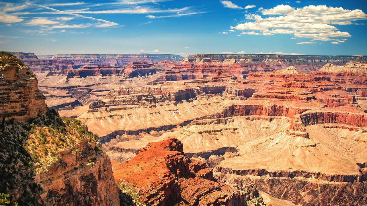 A view over the Grand Canyon under a blue sky with some white clouds