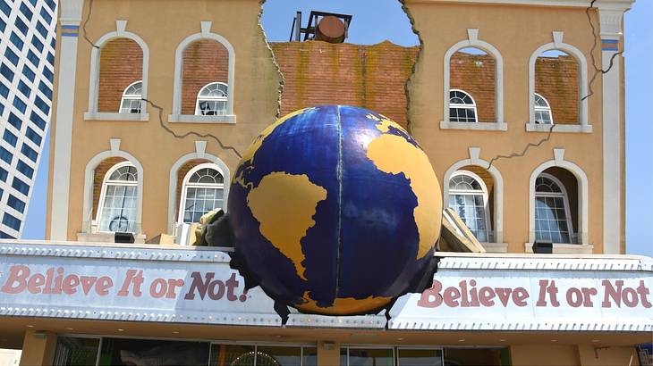 Ruins of a yellow building with a globe structure and a "Believe it or Not!" sign