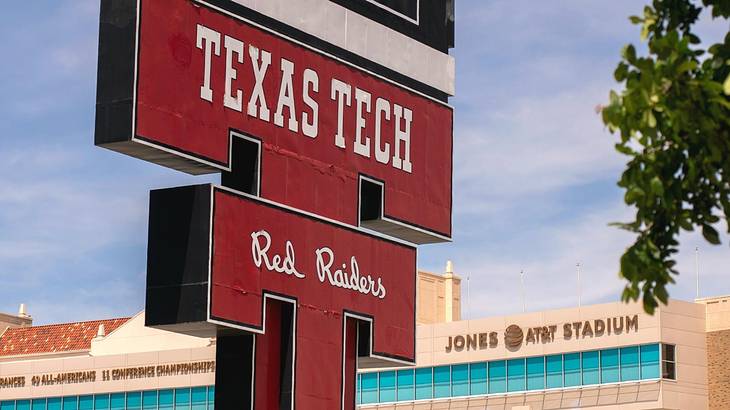 A red "Texas Tech, Red Raiders" sign next to a stadium with a "Jones AT&T" sign