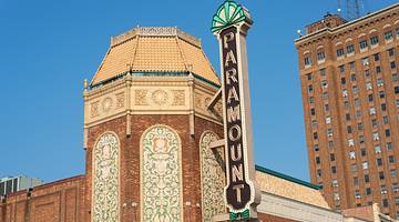 A building with a brick tower, tiled design, and a "Paramount" sign