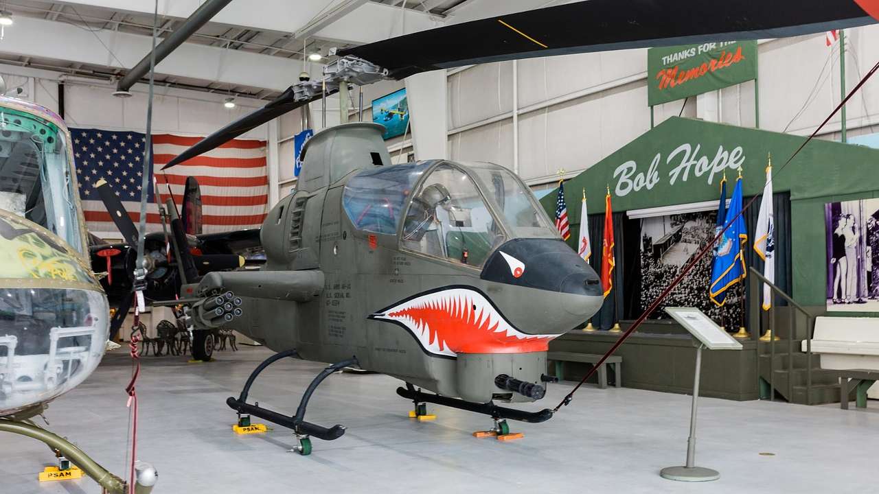 A fighter jet with a face painted on it inside a museum