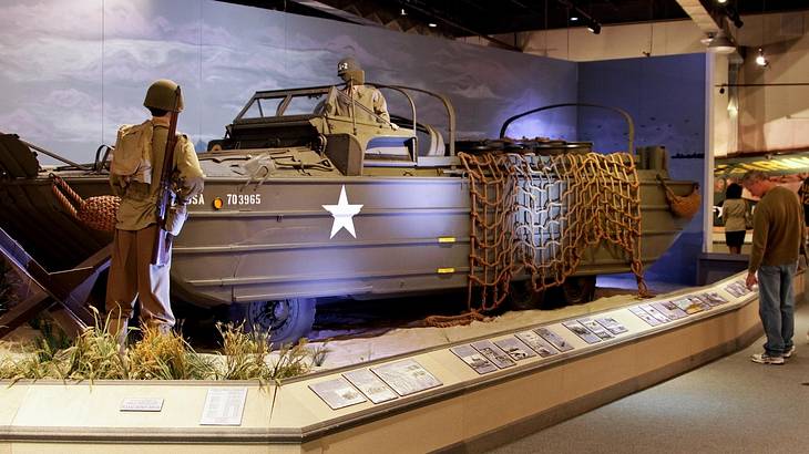An army boat replica with two solider models in a museum exhibit
