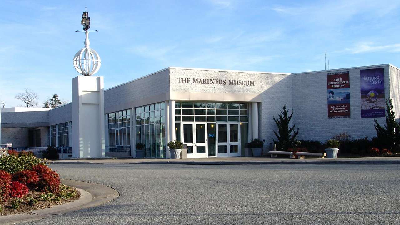 A museum with a sign that says "The Mariners' Museum" next to a statue