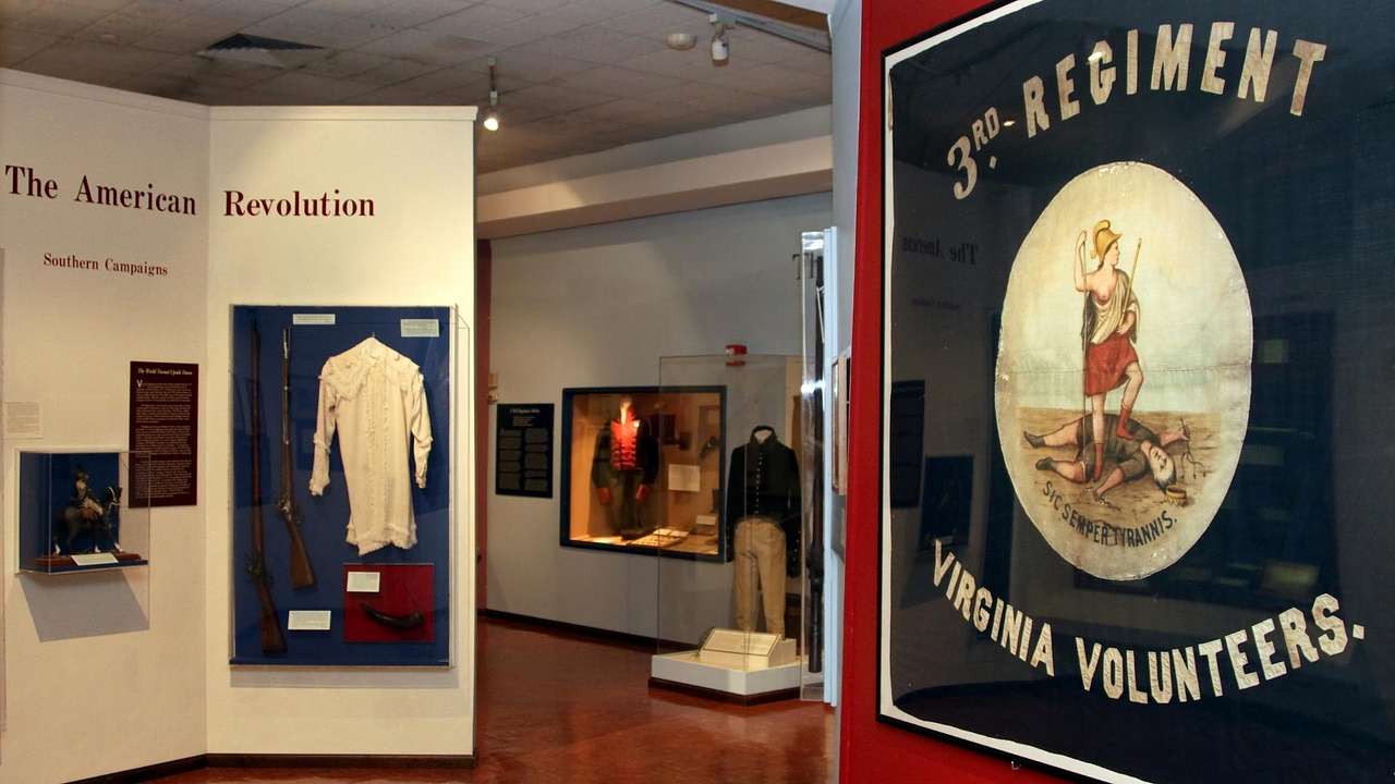 A military museum exhibit with an American Revolution display and army banner